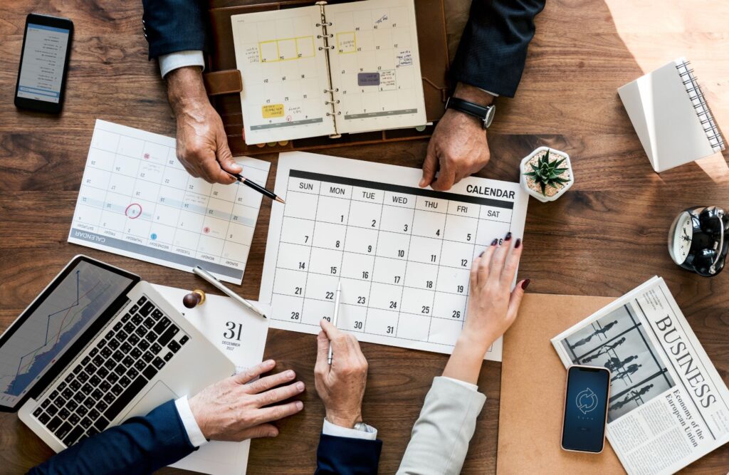 Team marking dates on a calendar to build a housing society compliance schedule