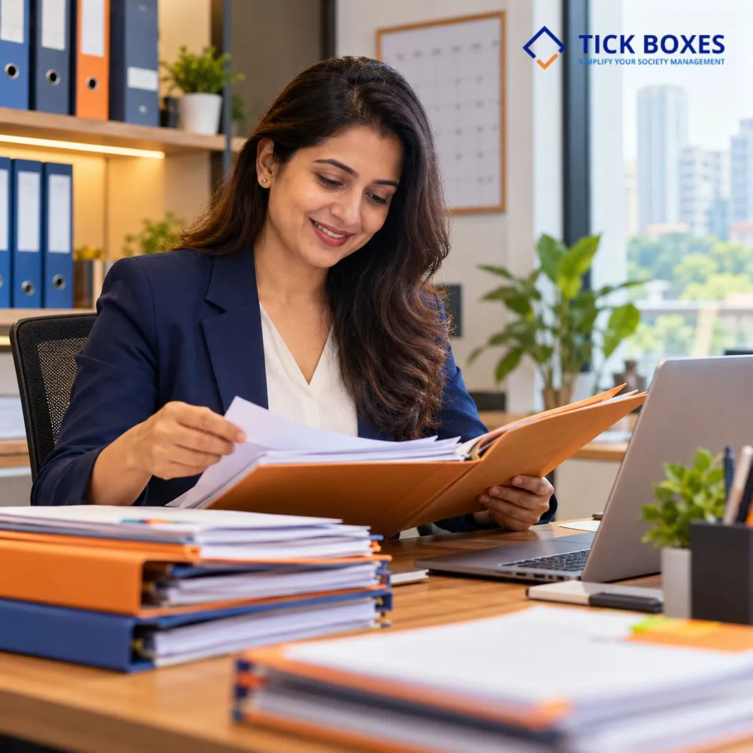 Society administration manager organising records and files at a desk for a housing society in Mumbai